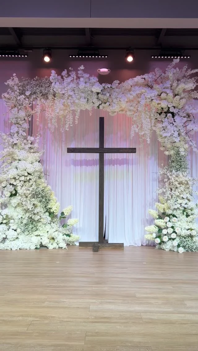 Romantic pink and white wedding floral arch in a church